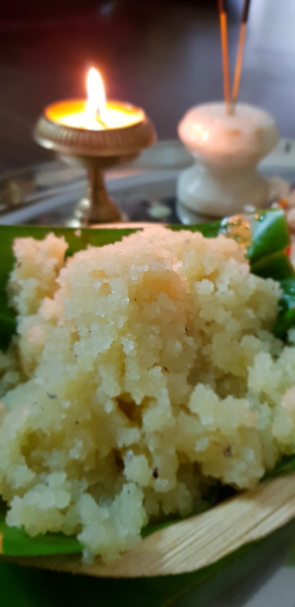 Sheera or Suji ka halwa on a banana leaf with a lamp and incense sticks.