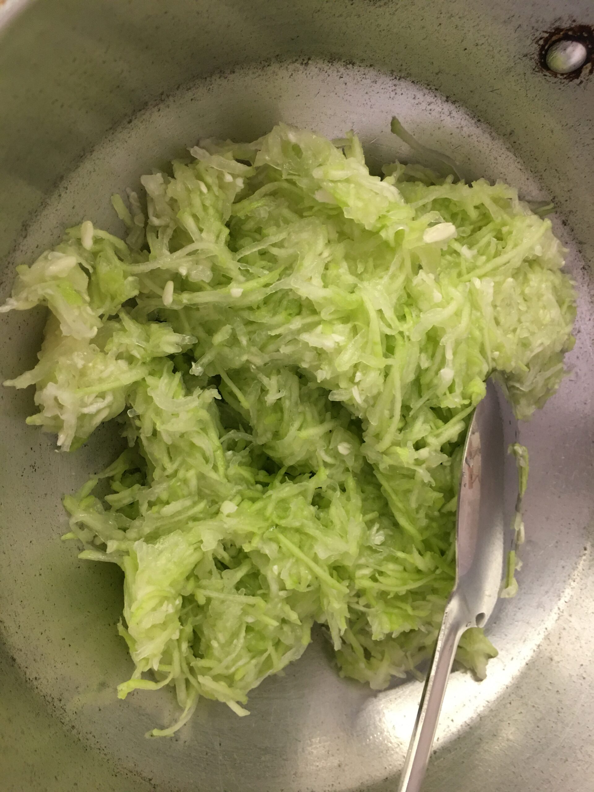 Adding grated dudhi to heated ghee