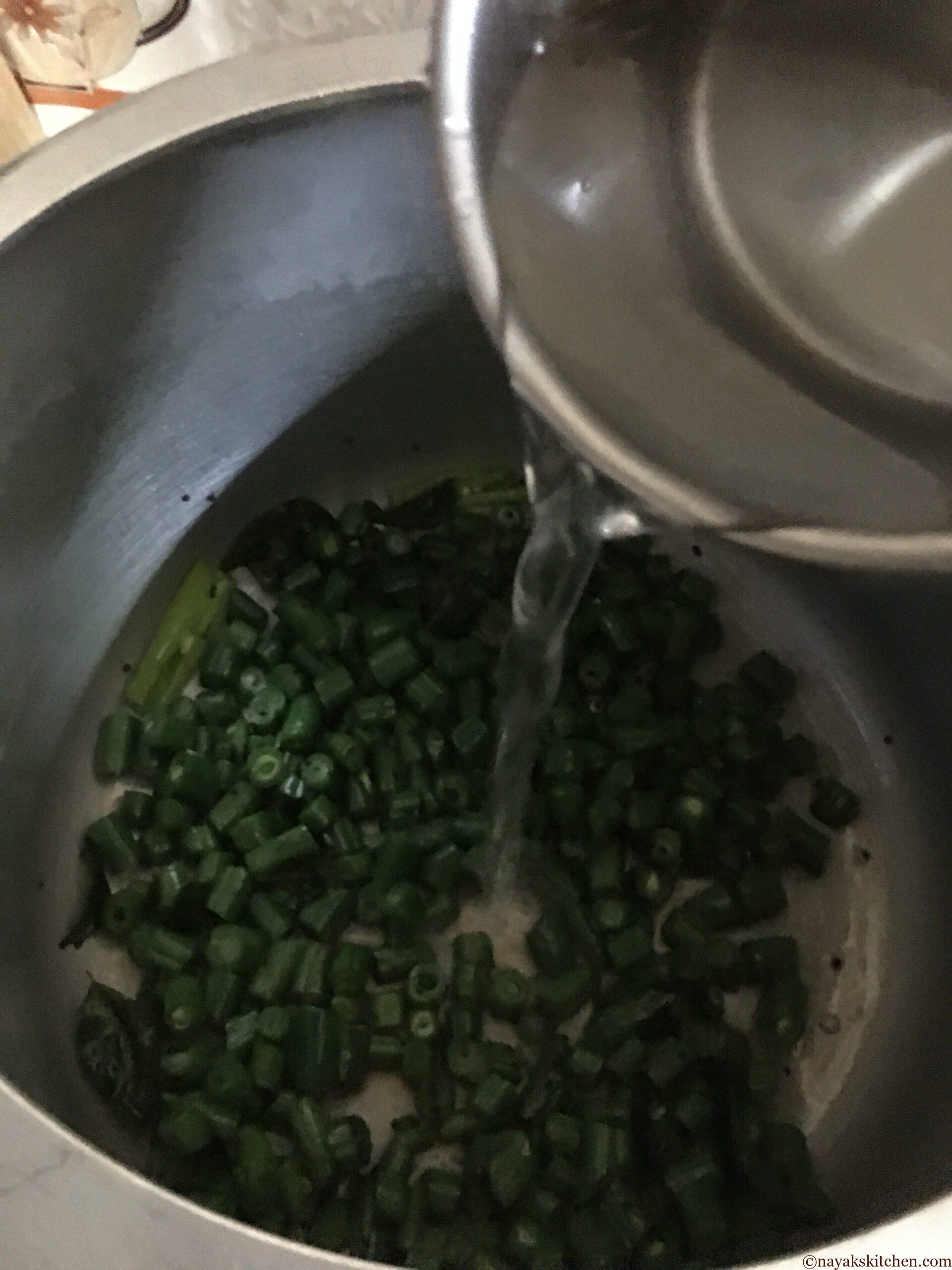 Adding water to val papdichi bhaji