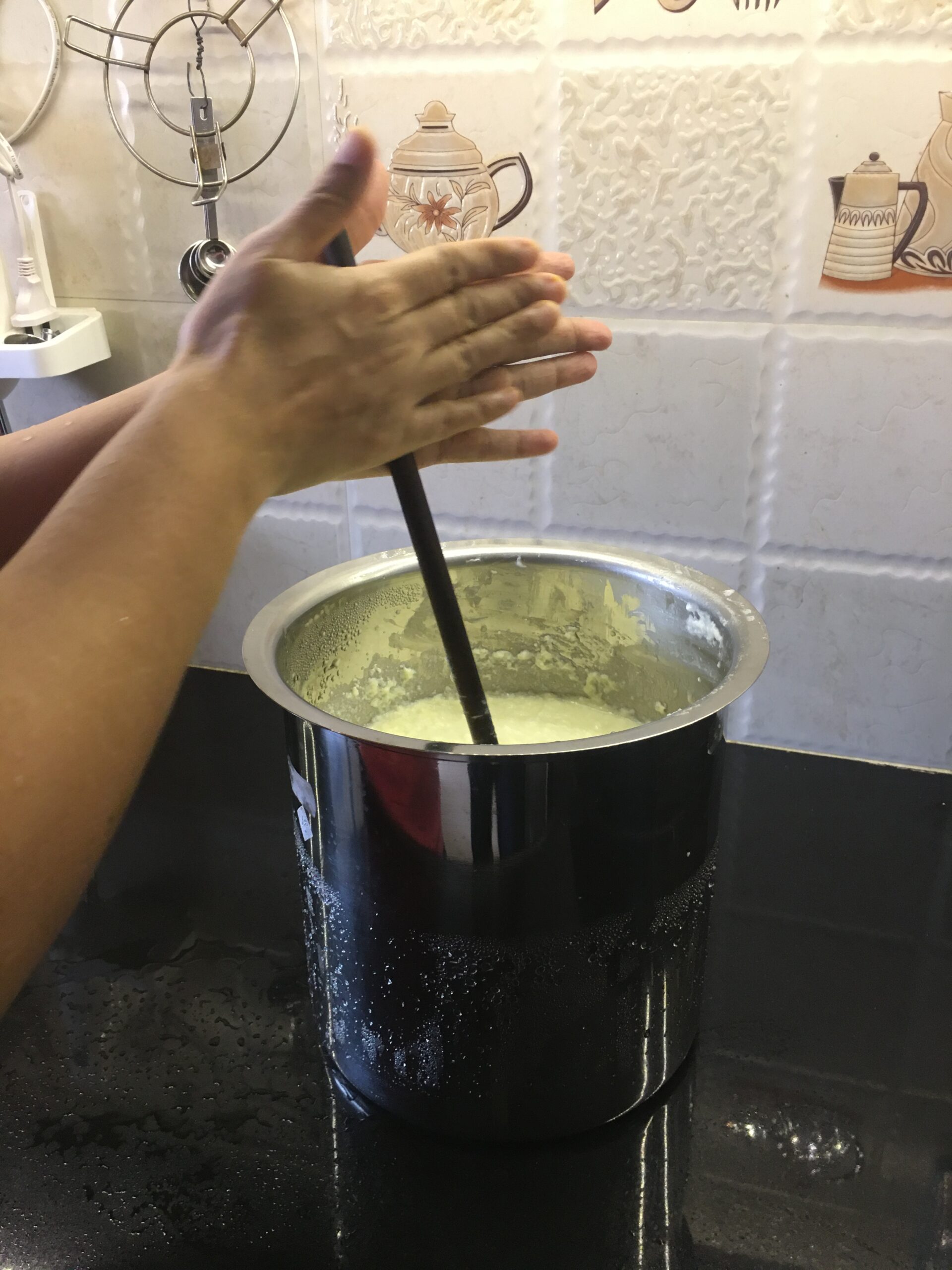 Churning cream with wooden churner