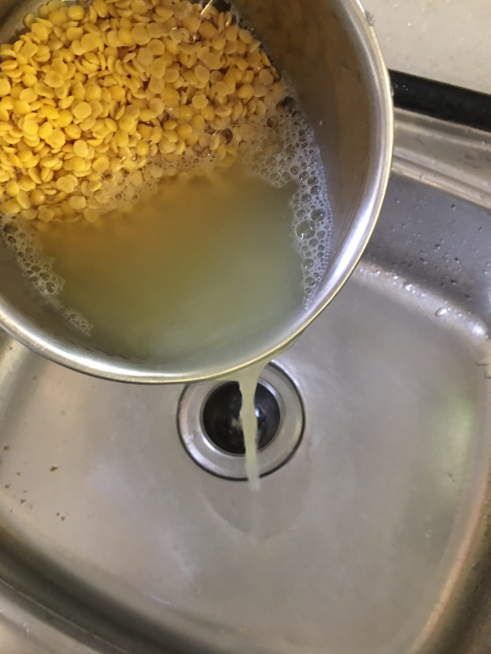 Draining water from soaked dal
