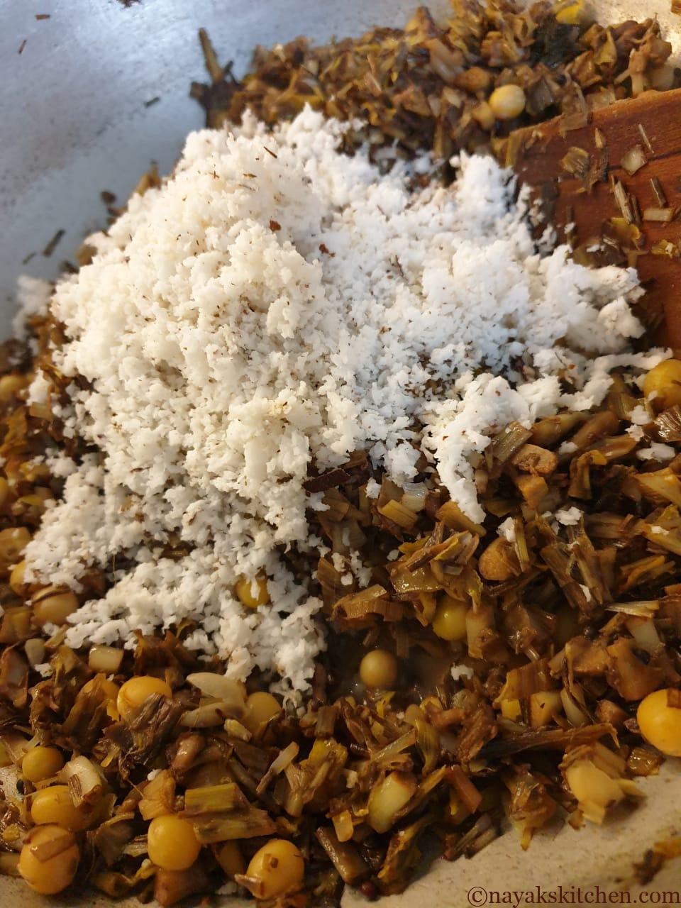 Adding coconut to banana blossom stir fry