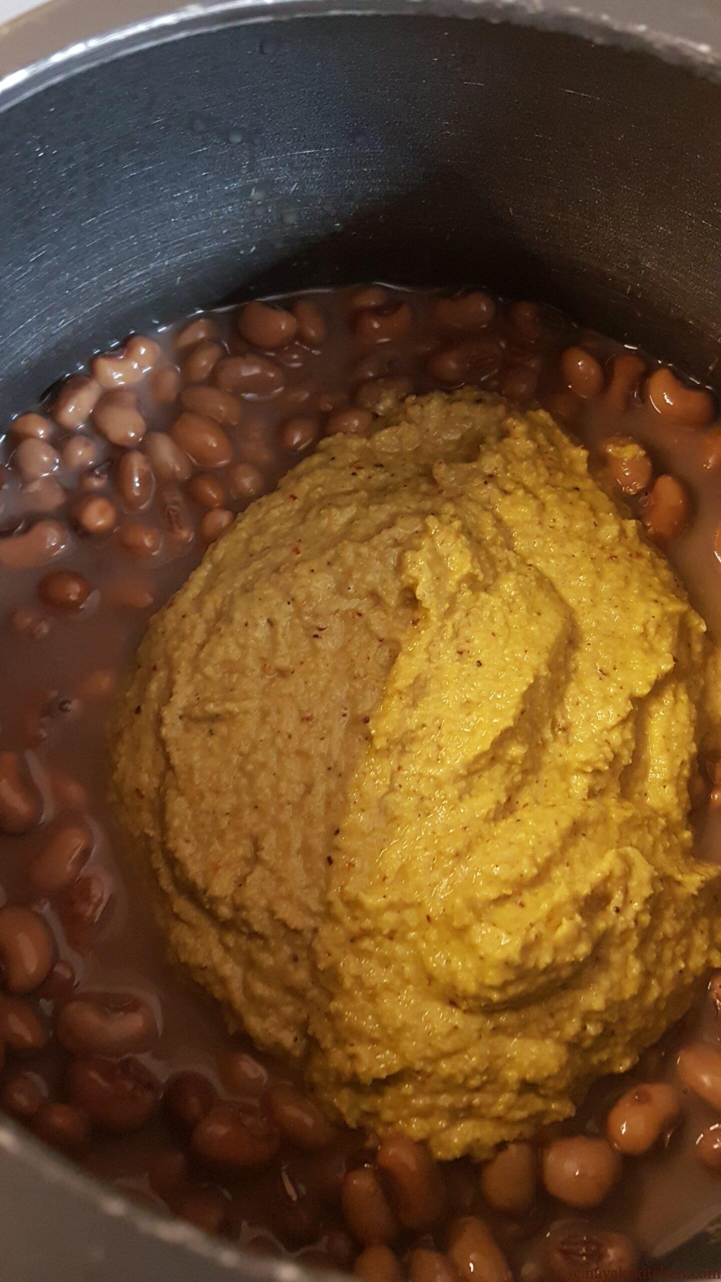Adding ground masala paste to cooked alsane