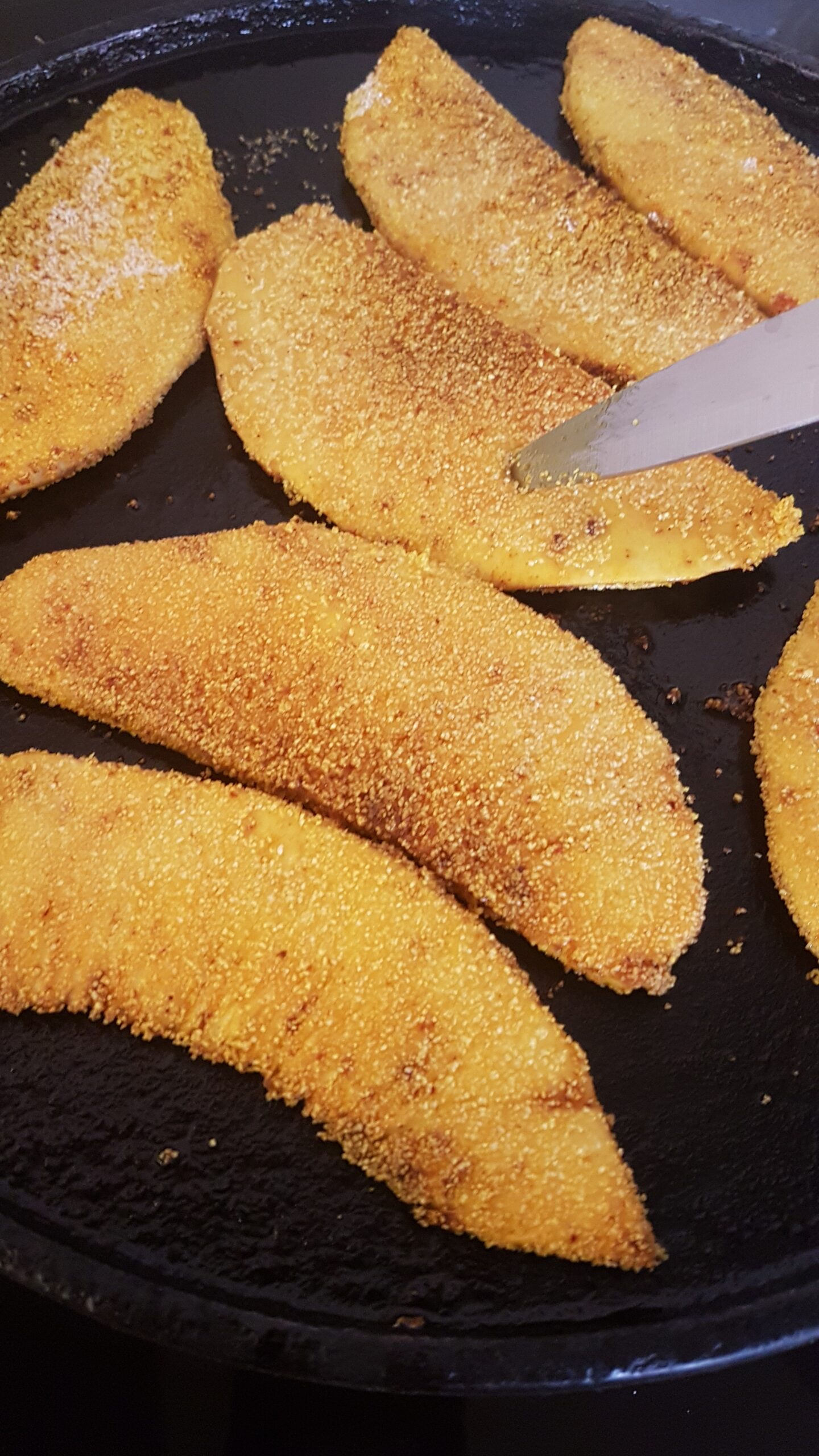 Piercing a knife to check if breadfruit has cooked