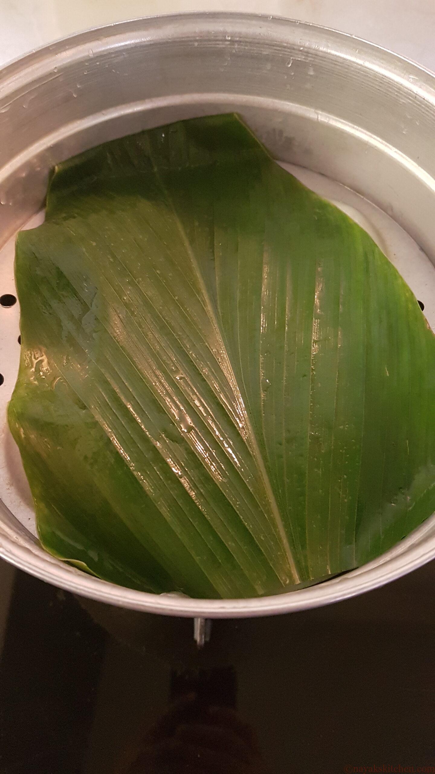 Placing a turmeric leaf in the steamer