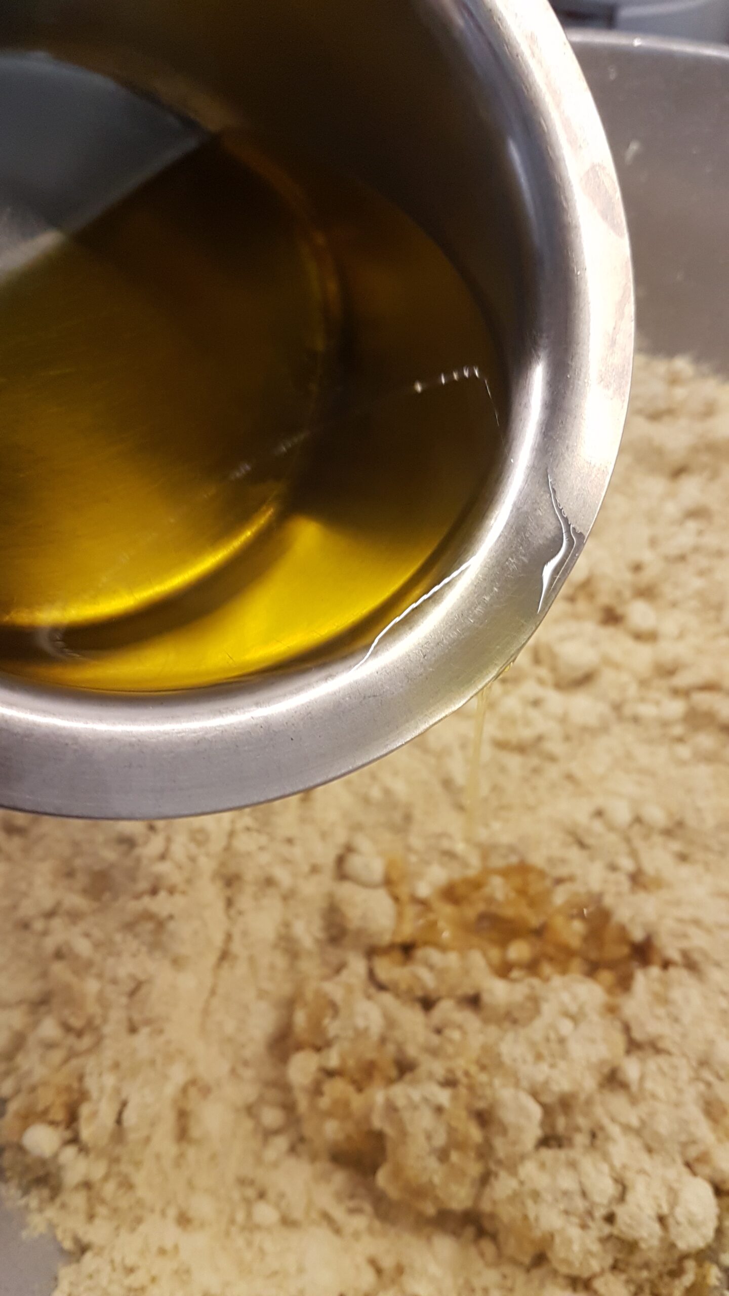 Adding warm ghee to roasted besan flour