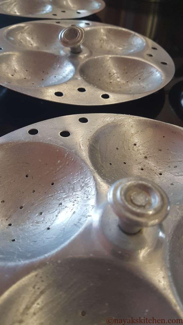 Applying ghee to all idli plates