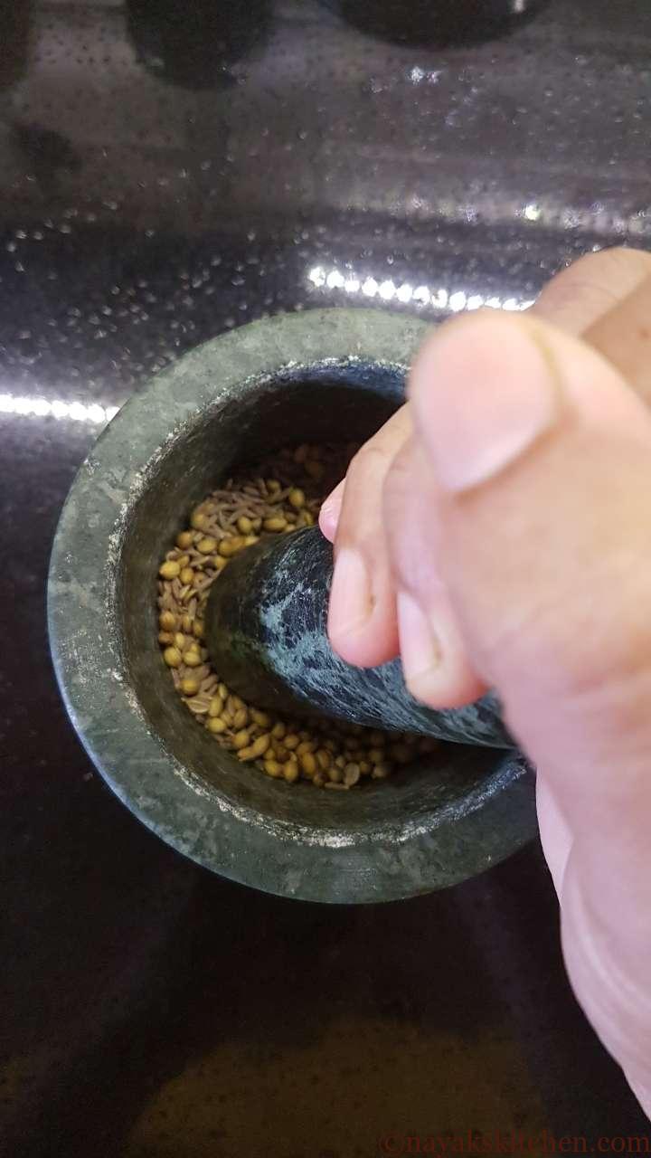 Pounding spices in a mortar pestle for Kashaya drink
