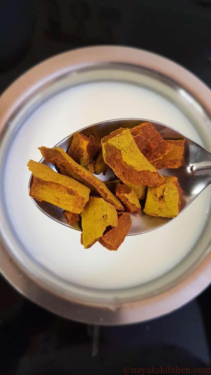 Adding pieces of turmeric roots to milk