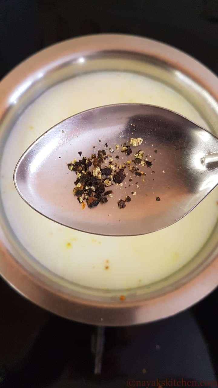 Adding crushed black pepper to milk