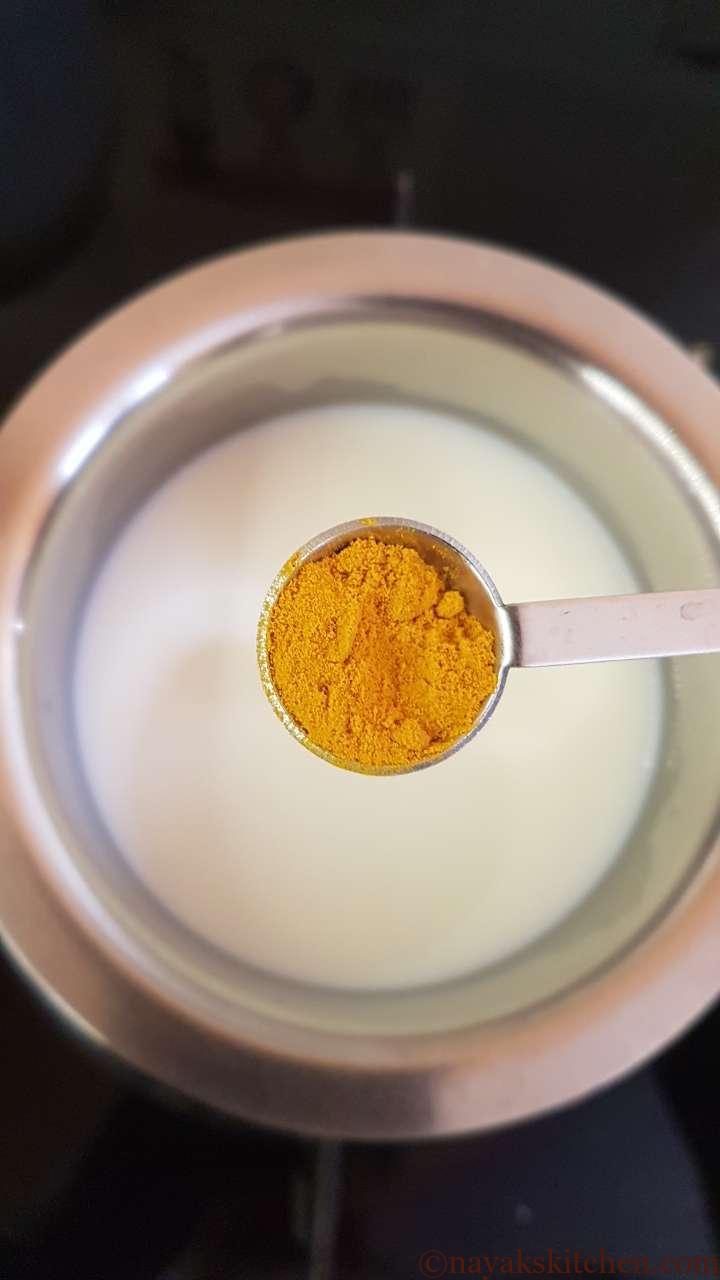 Adding turmeric powder (haldi)