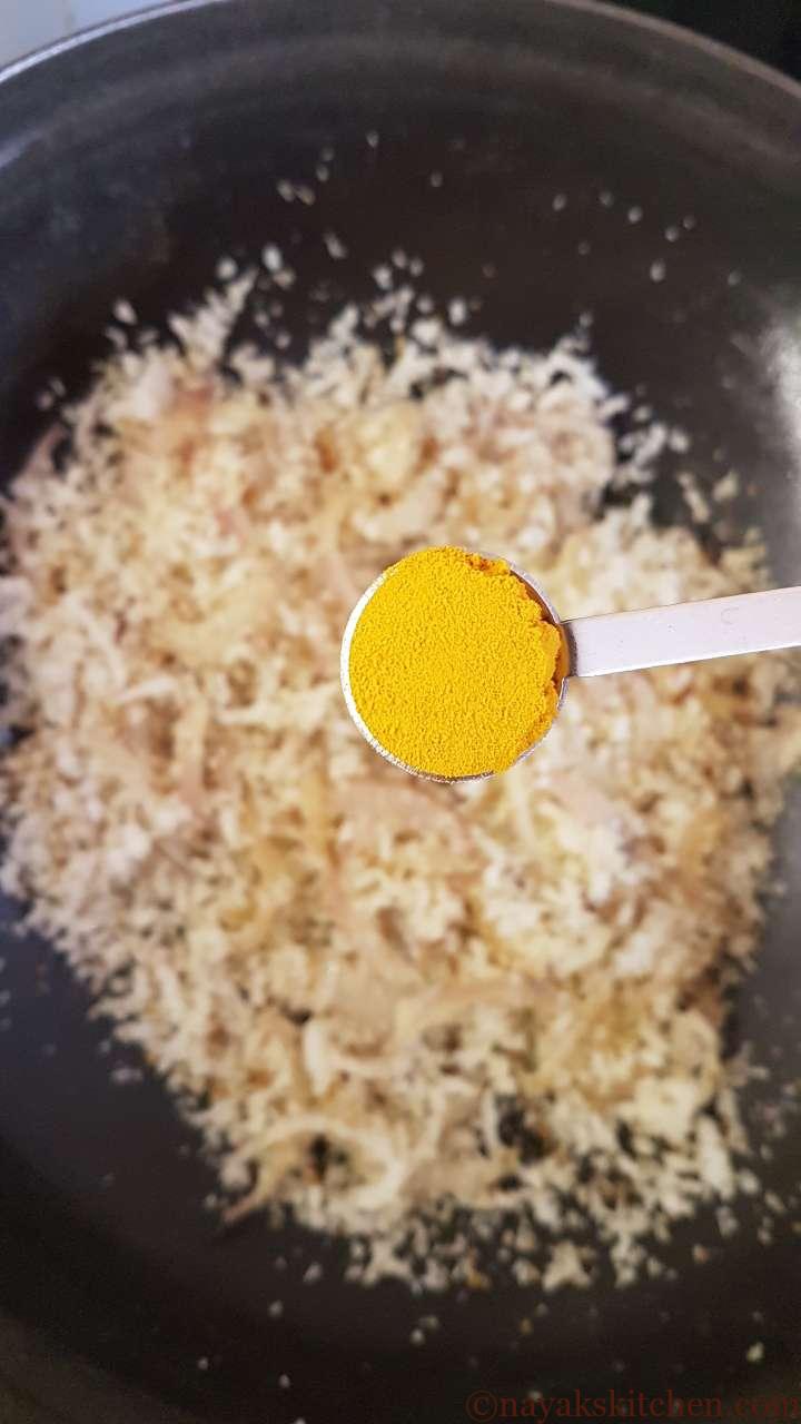 Adding turmeric to clams masala