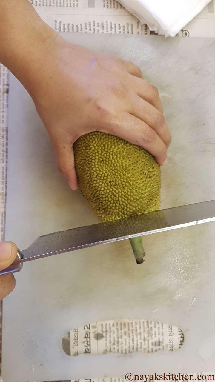 Chopping the stem or stalk of unripe jackfruit