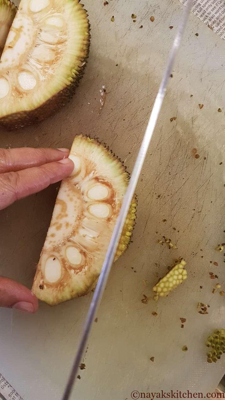 Chopping the outer green rind of raw jackfruit