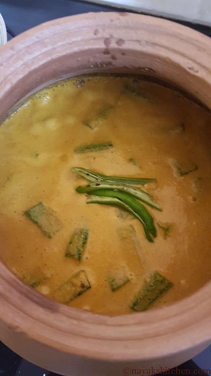 Adding slit green chillies to goan prawn curry recipe