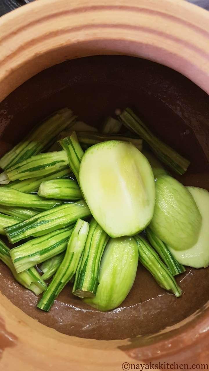 Cooking drumsticks and raw mango for goan prawns curry