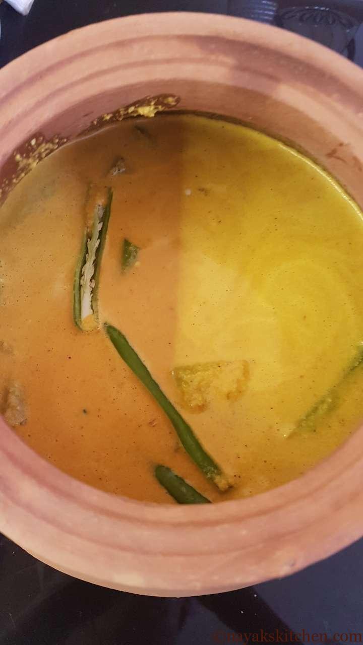 Adding slit green chillies to prawn curry