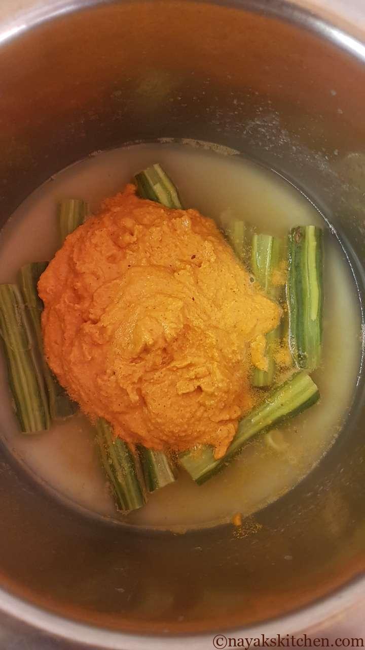 Adding ground paste to cooked drumsticks